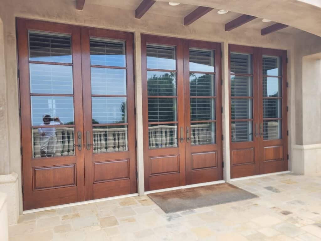 Elegant wooden patio doors with glass panels for outdoor living spaces.